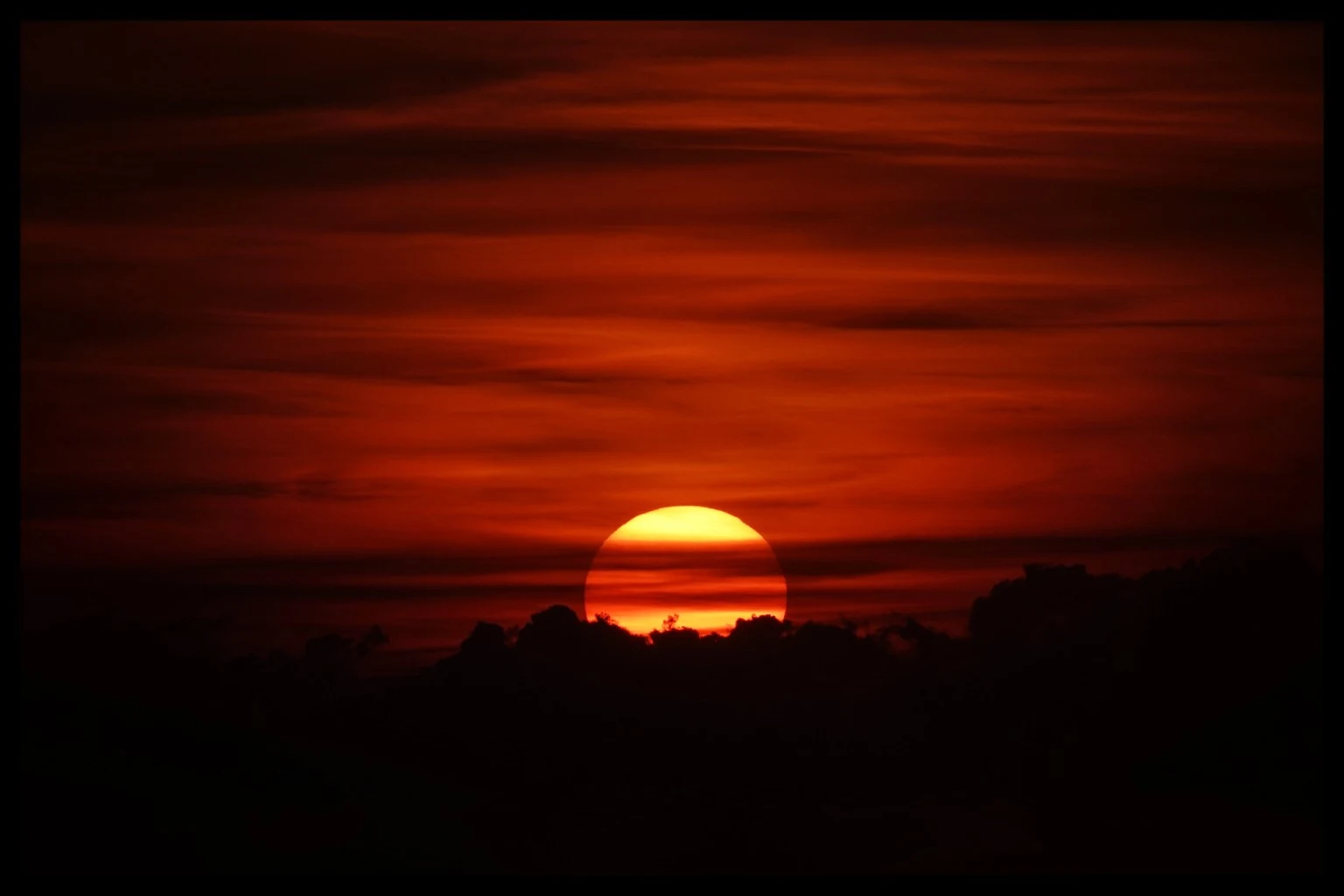 Soleil rouge au-dessus des nuages, photographié par Victor Dumoulin